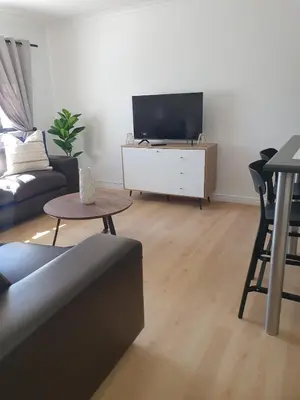 a living room with a couch and a tv at Lynwood Place in Cape Town