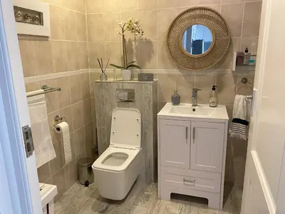 a bathroom with a toilet and a sink and a mirror at Bright apartment in Cape Town