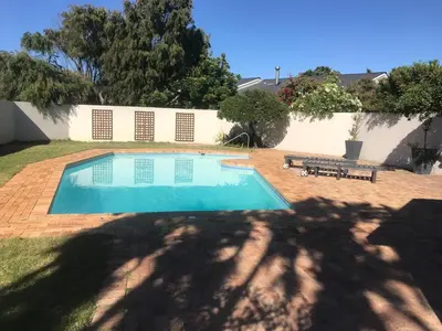 a swimming pool in the yard of a house at Bright apartment in Cape Town