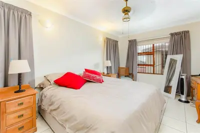 a bedroom with a bed with red pillows on it at Rehoboth in Cape Town