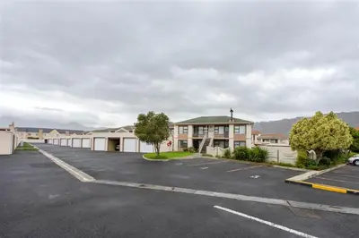 a parking lot in front of a row of houses at Rehoboth in Cape Town