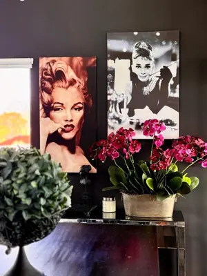 a table with flowers and pictures on a wall at Dior Maison de Reve- Private Penthouse in Stellenbosch