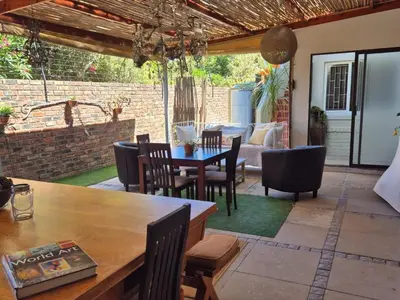 a patio with a wooden table and chairs at Afton Safari Lodge in Cape Town