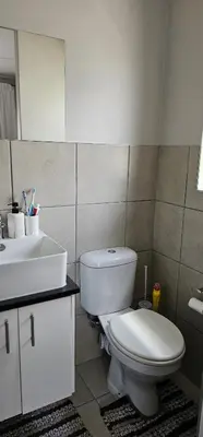 a bathroom with a white toilet and a sink at 33 Langeberg Heights in Cape Town