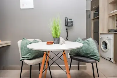 a kitchen with a table and two chairs and a phone at 18 on The Den Studio Apartment in Stellenbosch