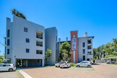 a white building with cars parked in front of it at 18 on The Den Studio Apartment in Stellenbosch