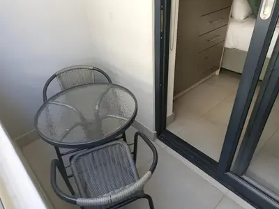 a table and a chair in a room at 18 on The Den Studio Apartment in Stellenbosch