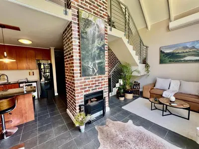 a living room with a brick fireplace and a couch at Enchanted View from Above in Stellenbosch