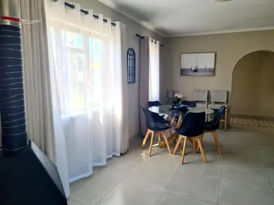 a dining room with a table and chairs at Flamingle at Coot in Cape Town