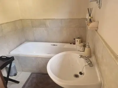 a bathroom with a white tub and a sink at LaMer in Bettyʼs Bay
