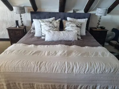 a bedroom with a large bed with white sheets and pillows at LaMer in Bettyʼs Bay