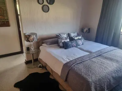 a bedroom with a bed with pillows on it at LaMer in Bettyʼs Bay