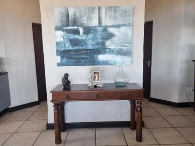 a table with a vase on it in a room at La Mer in Bettyʼs Bay