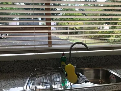 a kitchen sink with a dish drying rack next to a window at Tolbos Grand in Somerset West