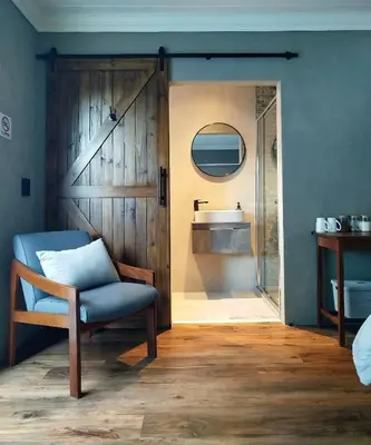 a bathroom with a sliding barn door with a sink at Tide's whisper in Hermanus