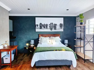 a bedroom with a bed and a wall with elephants at Tide's whisper in Hermanus