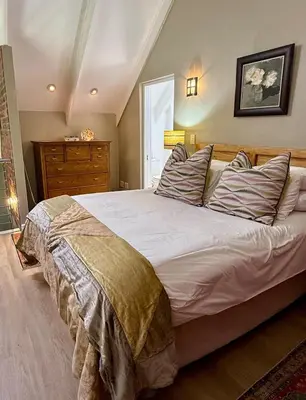a bedroom with a large bed and a dresser at Urban Oasis loft in Stellenbosch in Stellenbosch