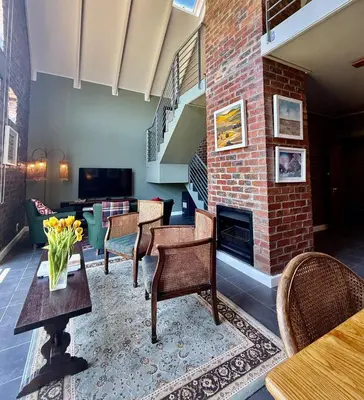 a living room with chairs and a brick fireplace at Urban Oasis loft in Stellenbosch in Stellenbosch