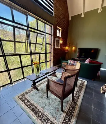 a living room with a table and chairs and a couch at Urban Oasis loft in Stellenbosch in Stellenbosch