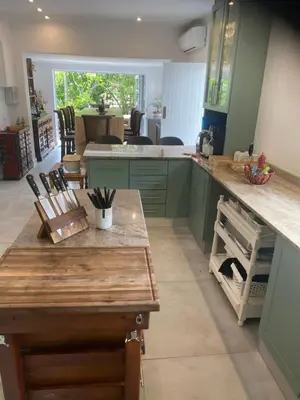 a kitchen with green cabinets and a counter top at 8 Sleeper, 4 Bedroom Home in Franschhoek in Franschhoek