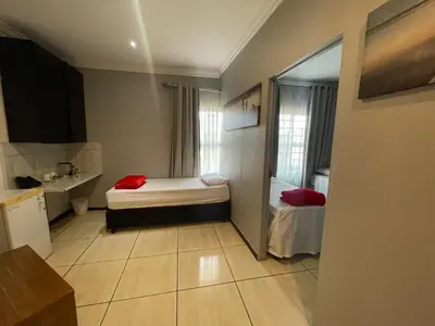 a small room with a bed and a sink at Ayan Contractors & Student Accommodation in Avondale