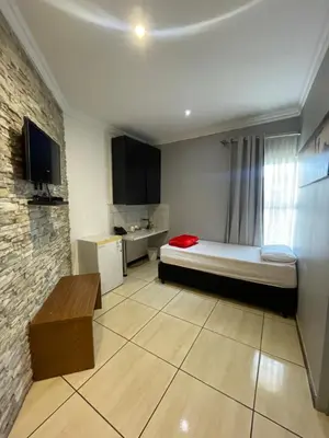 a small room with a bed and a television at Ayan Contractors & Student Accommodation in Avondale