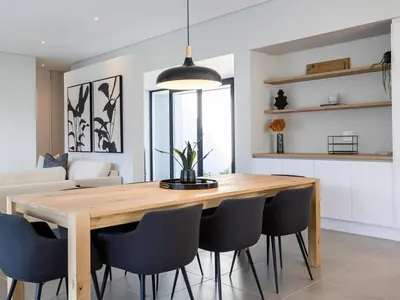 a dining room with a wooden table and chairs at Luxury Golf Villa 710, Pearl Valley Golf Estate in Simondium