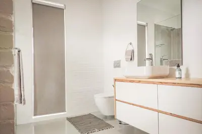 a bathroom with a sink and a toilet at Swallows Perch Beach Getaway - Solar Backup in Bettyʼs Bay
