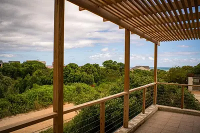 a view from the porch of a house with a wooden deck at Swallows Perch Beach Getaway - Solar Backup in Bettyʼs Bay