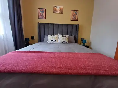 a bedroom with a large bed with a red blanket at Oakway Guest Suite 2 Beds 1Bath Aircon Kitchen Private in Kuilsrivier