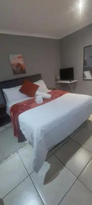a bedroom with a large white bed with red sheets at The Resting Nest in Mandalay