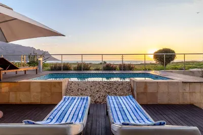 a swimming pool with two lounge chairs and an umbrella at 