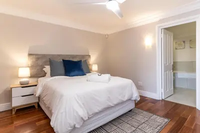 a bedroom with a large white bed with blue pillows at 