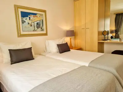 two beds in a hotel room with at 'Goldwater on Beach' - 3 Bedroom Beachfront with Balcony & BBQ - Sleeps 6 in Gordonʼs Bay