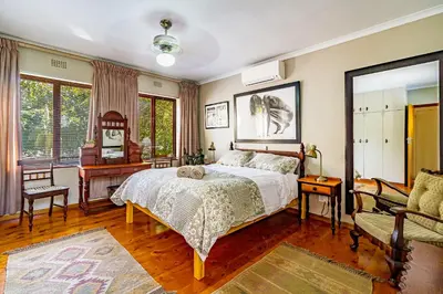 a bedroom with a bed and a table and a couch at 5 on Paul Kruger in Somerset West