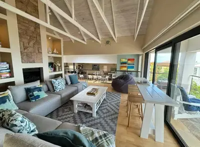 a living room with a couch and a table at Onrus Beach House in Hermanus