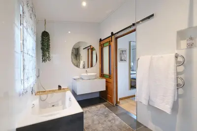 a white bathroom with a sink and a mirror at Esperon in Stellenbosch