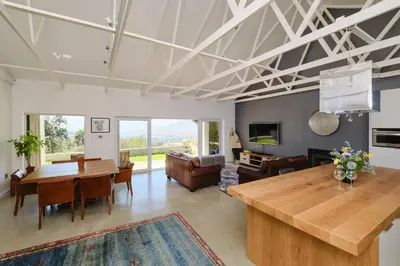 a living room with a table and a dining room at Esperon in Stellenbosch