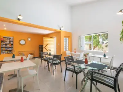 a dining room with tables and chairs and orange walls at Cape Town 4U Guesthouse in Cape Town
