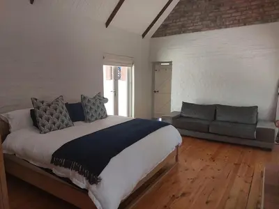 a bedroom with a large bed and a couch at Greystone in Greyton
