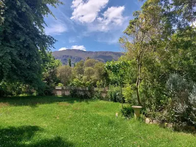 a yard with a fence and green grass and trees at Greystone in Greyton