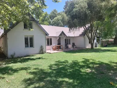 a white house with a yard with a table and chairs at Greystone in Greyton