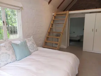 a bedroom with a bed and a staircase in a room at Greystone in Greyton