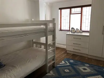 a bedroom with two bunk beds and a window at Onrus Home with a Sea View in Hermanus