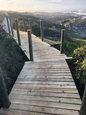 a wooden path on a hill with a view at Onrus Home with a Sea View in Hermanus