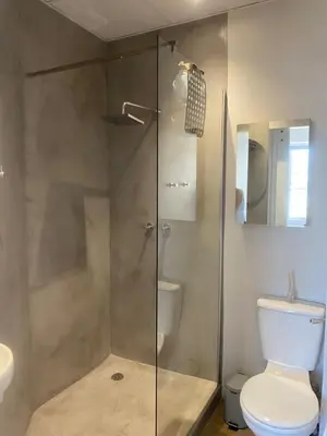 a bathroom with a glass shower with a toilet at Pistachio - Paarl - Self Catering Apartment in Paarl