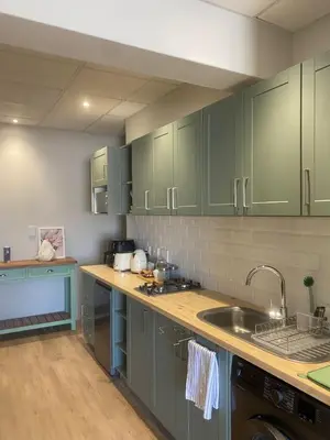 a kitchen with green cabinets and a sink at Pistachio - Paarl - Self Catering Apartment in Paarl
