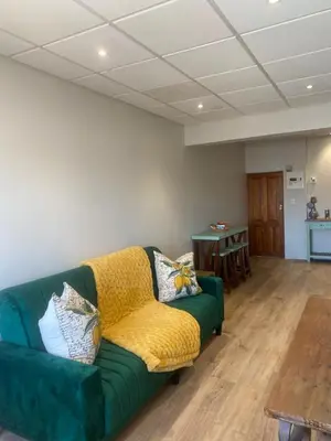 a living room with a green couch and a table at Pistachio - Paarl - Self Catering Apartment in Paarl