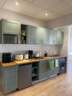 a kitchen with green cabinets and a stove top oven at Pistachio - Paarl - Self Catering Apartment in Paarl
