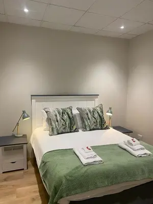 a bedroom with a bed with two towels on it at Pistachio - Paarl - Self Catering Apartment in Paarl